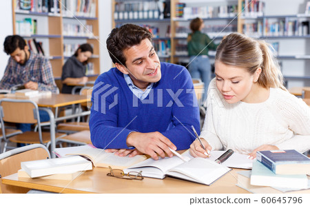 Young people preparing for exam in library Young people preparing for exam in library 60645796