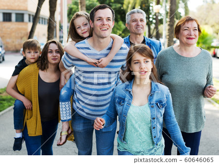 Smiling people of different ages walk in the park 60646065