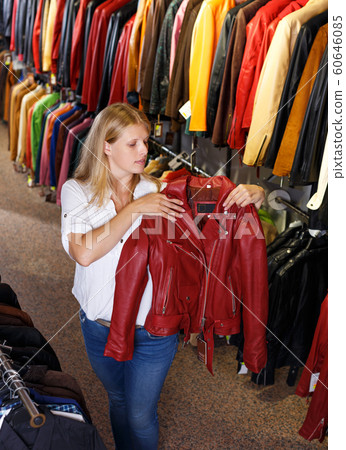 blonde choosing leather jacket on racks blonde choosing leather jacket on racks 60646085