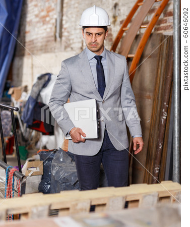 Manager using laptop with blueprints Manager using laptop with blueprints 60646092