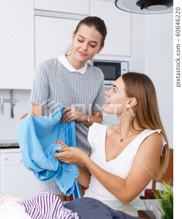 Girls trying clothes in kitchen Girls trying clothes in kitchen 60646220