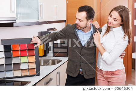 Couple choosing materials for kitchen furnishing Couple choosing materials for kitchen furnishing 60646304