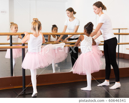 Girls practicing elements on ballet barre 60646341