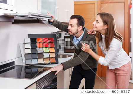 Spouses shoosing kitchen furniture in salon 60646557