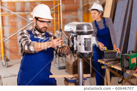Man is worker behind drilling machine 60646707