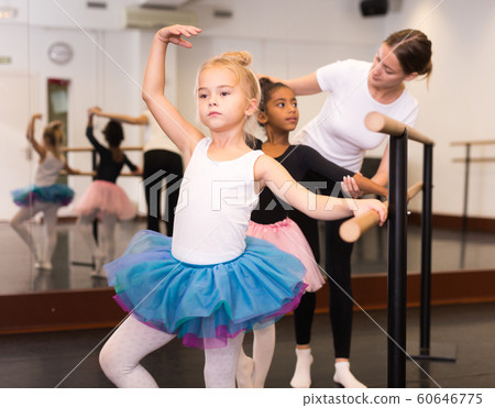 Ballet trainer teaching two little girls 60646775