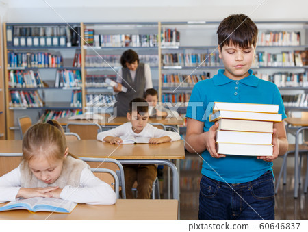 Happy tween boy standing with books Happy tween boy standing with books 60646837