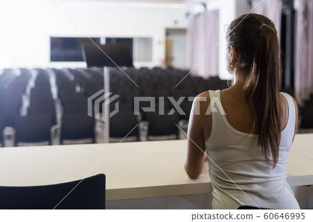Woman sitting opposite to empty hall 60646995