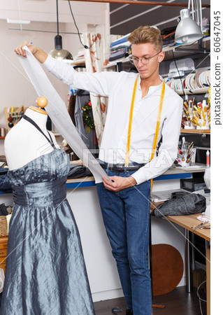 Fashion designer standing near tailor mannequin 60647045