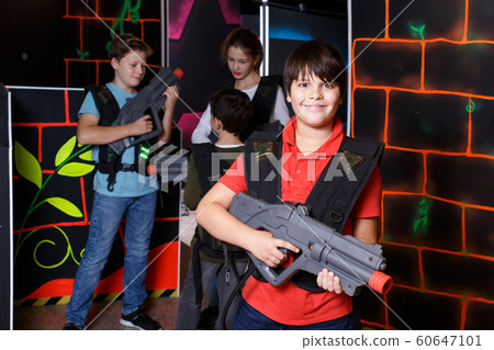 Portrait of teen boy standing with laser gun Portrait of teen boy standing with laser gun 60647101