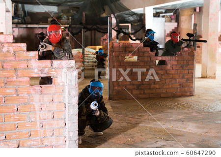 Paintball players aiming in opponents 60647290