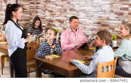 Father, mother and children are giving order to cheerful waitress Father, mother and children are giving order to cheerful waitress 60647401