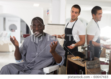 Shocked African man with confused hairdresser Shocked African man with confused hairdresser 60647483