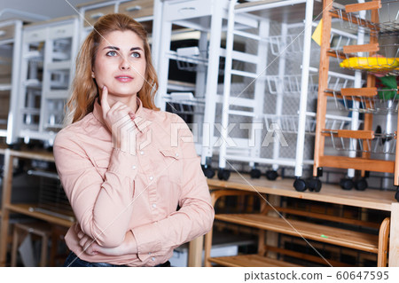 Girl thinking about buying in shop Girl thinking about buying in shop 60647595