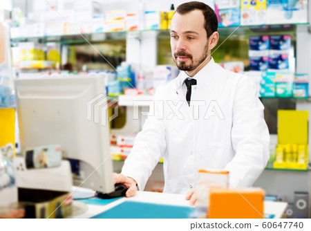 Male pharmacist checking assortment of drugs Male pharmacist checking assortment of drugs 60647740