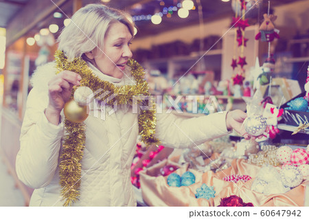 Adult woman is choosing decorations for Christmas tree in the market 60647942