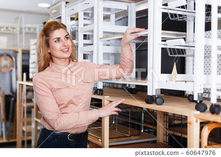 Girl choosing utility cart for kitchen storage 60647976