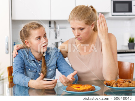 Sad teenage girl and her surprised mother 60648043