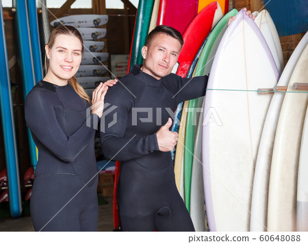 guy and girl with equipment for surfing guy and girl with equipment for surfing 60648088