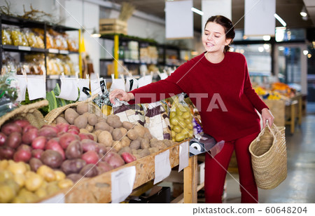 Woman chooses potatoes Woman chooses potatoes 60648204