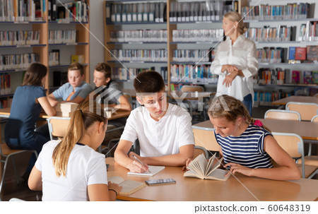 Smiling boys and girls brainstorming in teams Smiling boys and girls brainstorming in teams 60648319