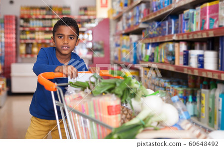 teenager boy with shopping cart in supermarket 60648492