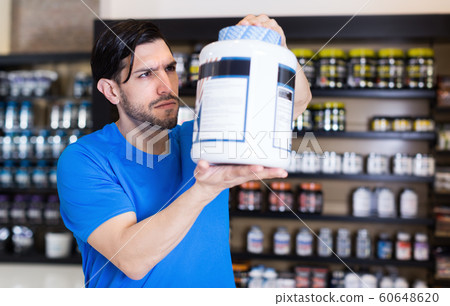 Serious muscular sportman looking sport nutrition products 60648620