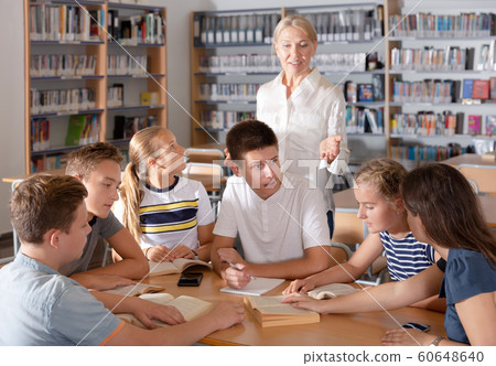 Group of glad schoolers discussing with teacher 60648640