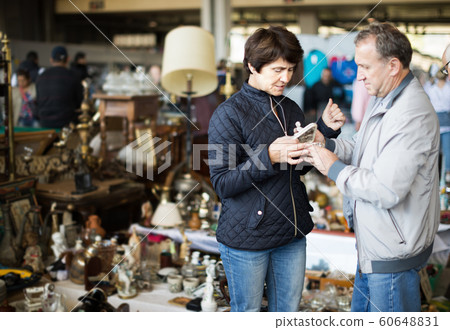 Mature couple choosing vintage artifacts at fleamarket 60648831