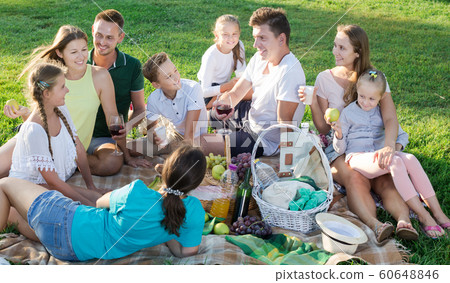 Group of joyful people with kids enjoying picnic Group of joyful people with kids enjoying picnic 60648846