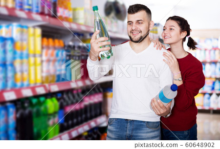 Young family purchasing soft dinks 60648902