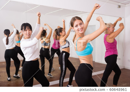 Fitness women practicing zumba movements 60648961