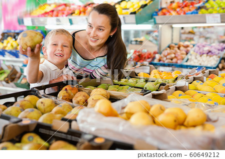 Cheerful mother with little boy buying pears and apples at store 60649212