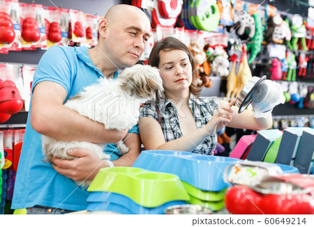 Portrait of smiling couple purchasing new pet bowls in pet store Portrait of smiling couple purchasing new pet bowls in pet store 60649214