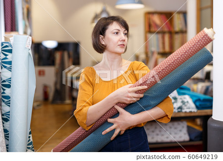 Saleswoman arranging cloth rolls Saleswoman arranging cloth rolls 60649219