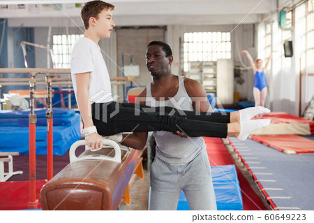 trainer helping teenage athlete with exercise technique trainer helping teenage athlete with exercise technique 60649223