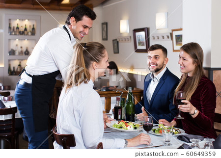 Waiter bringing dishes to guests Waiter bringing dishes to guests 60649359