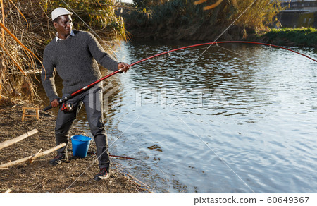 Afro fisherman pulling fish Afro fisherman pulling fish 60649367