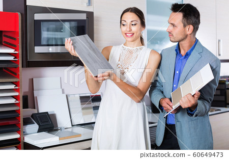 Couple choosing material for facades for their future kitchen Couple choosing material for facades for their future kitchen 60649473