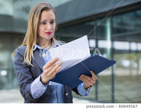 Adult female architect with paper documents 60649567