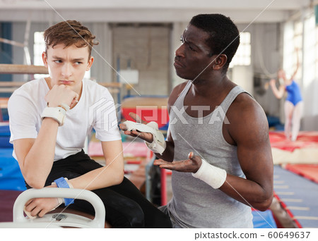 Coach comforting boy at gym 60649637