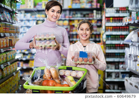 Female shopper with teenage daughter searching for eggs 60649679