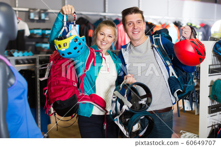 Modern couple is choosing travel gear in shop 60649707