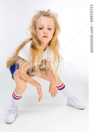 Sports teenager girl in sport suit do exercises isolated on background 60654723