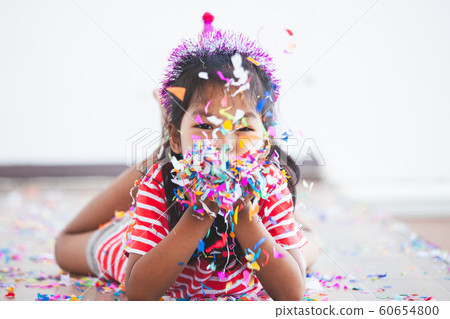 asian child girl with colorful confetti to celebrate in her party 60654800