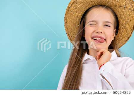 Fashionable teenager girl in blue t-shirt gesticulates, portrait isolated on blue background 60654833