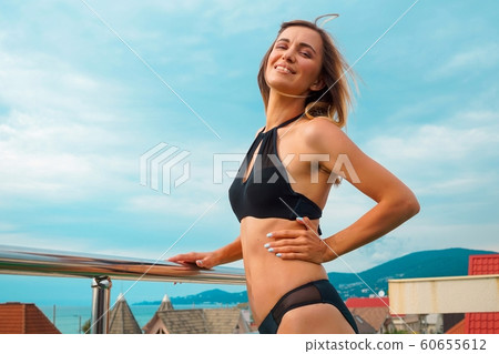 Beautiful tanned woman portrait at resort with beautiful view Beautiful tanned woman portrait at resort with beautiful view 60655612