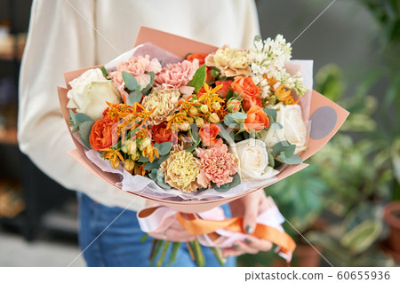 European floral shop. Beautiful bouquet of mixed flowers in womans hands. the work of the florist at a flower shop. Delivery fresh cut flower. European floral shop. Beautiful bouquet of mixed flowers in womans hands. the work of the florist at a flower shop. Delivery fresh cut flower. 60655936
