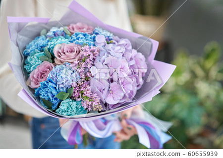 European floral shop. Beautiful bouquet of mixed flowers in womans hands. the work of the florist at a flower shop. Delivery fresh cut flower. European floral shop. Beautiful bouquet of mixed flowers in womans hands. the work of the florist at a flower shop. Delivery fresh cut flower. 60655939