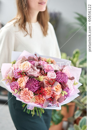 European floral shop. Beautiful bouquet of mixed flowers in womans hands. the work of the florist at a flower shop. Delivery fresh cut flower. European floral shop. Beautiful bouquet of mixed flowers in womans hands. the work of the florist at a flower shop. Delivery fresh cut flower. 60656122